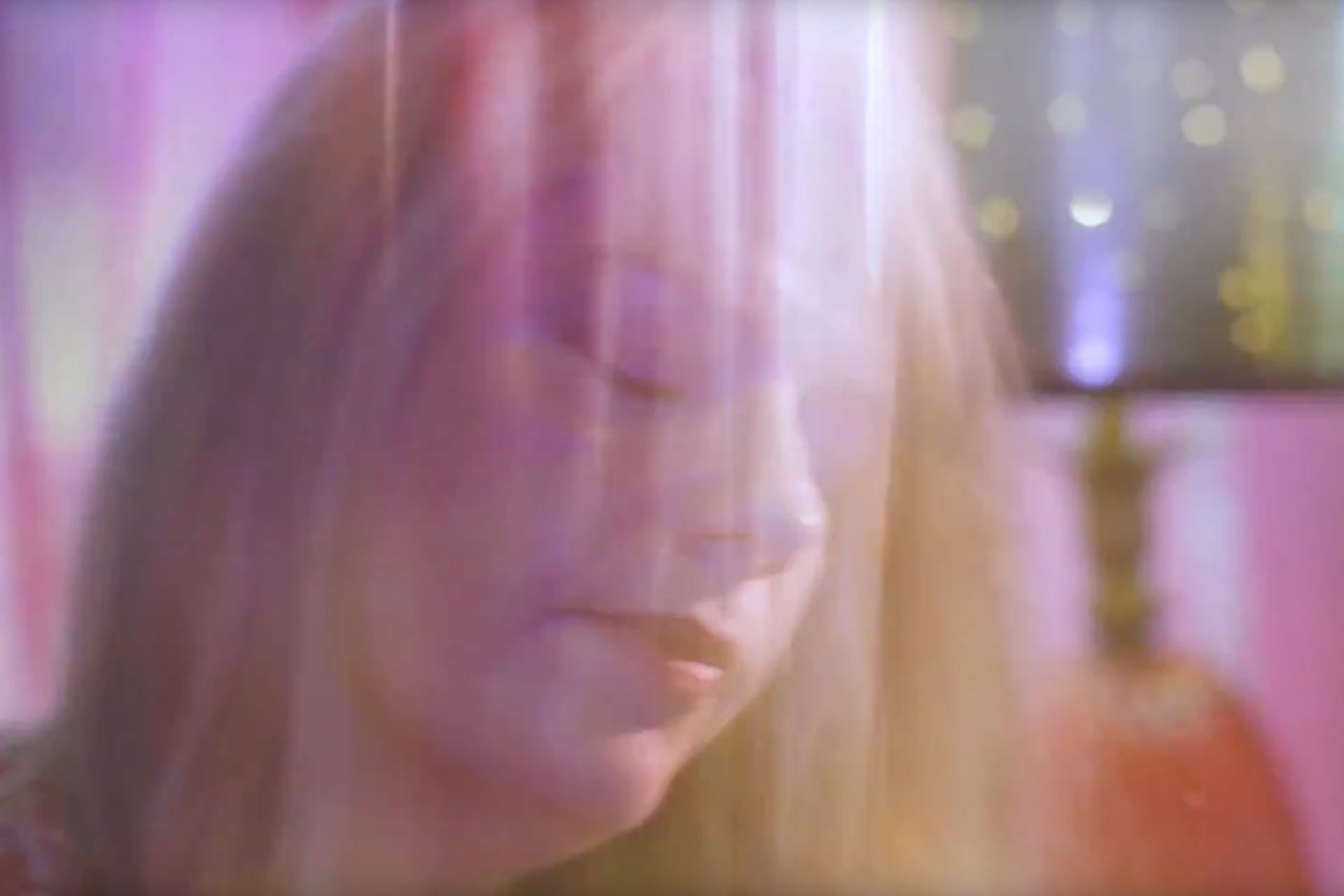 Rebecca in a still frame from Black Coral video, with color overlays over her face